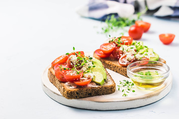 Avocado tomatoes goat cheese sandwiches. Selective focus, space for text.