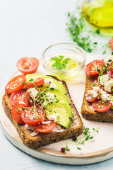 Avocado tomatoes goat cheese sandwiches. Selective focus, space for text.