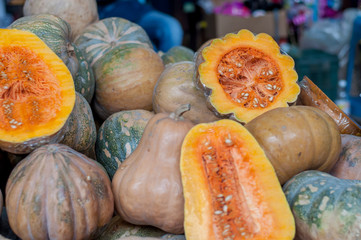 calabazas naturales partidas en color naranja en el mercado
