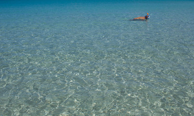Obraz premium Swim, diving man. Beautiful panorama with the Mediterranean sea in Sardinia, Italy. crystal and colorful water. Beautiful sky. Travel life.