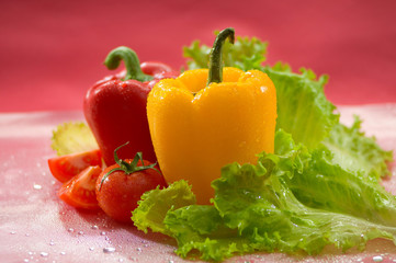 Овощи - помидоры, перец, салат, на красном фоне Vegetables - tomatoes, peppers, lettuce on a red background