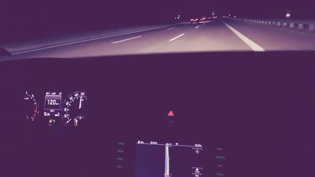 Driving fast on German autobahn highway at night - purple color cast - dashboard showing 120 kmh