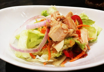 Tuna salad in white plate on black table
