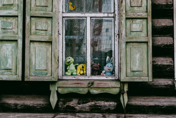 Fototapeta na wymiar children's toys on the old village window