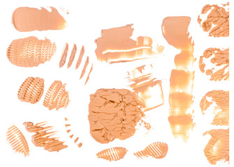 Blots and smears of concealer made with a figured palette knife isolated on white background.