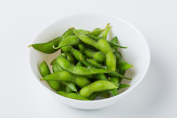 White bowl with soy beans, edamame on white bnackground