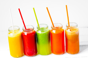 Fresh detox juices glass in row bottles on white background