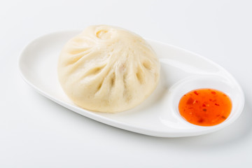 Traditional dim sum dumpling on plate with chili sauce