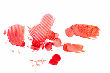 Pieces of lipstick cut and crushed with a figured palette knife isolated on white.