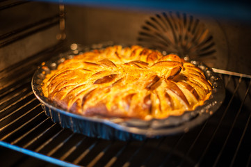 Apple pie baking in the oven. Ready. Process of preparation of apple pie. Homemade. Soft focus,...