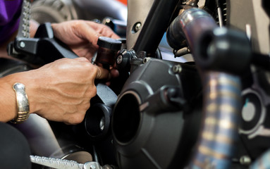 People use hand are repairing a motorcycle Use a wrench to work. Use the wrench to tighten the...