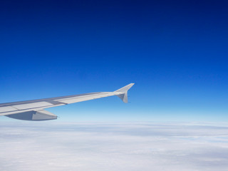 aircraft wing above the white clouds sky high for holiday travelling 