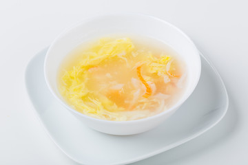 soup in the white bowl with shrimp, calamari, surimi, eggs