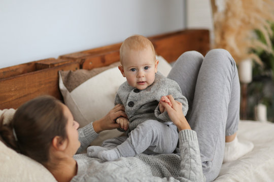 Mother And Son Laugh In Real Room, Baby On Hands