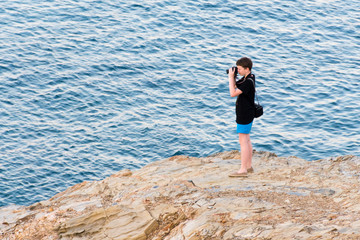 young man photographs the sea