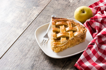 Homemade apple pie slice on wooden table. Copyspace