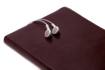 Notebook and white headphones isolated on the white background