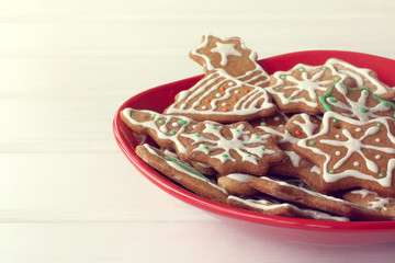 festive dessert for Christmas/ red plate full of different shaped cookies on the table front view