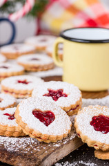 Linzer cookies with raspberry jam on festive table.