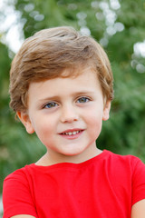 Happy child with red t-shirt in the garden