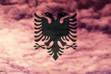 Albanian flag with cloud sky background.