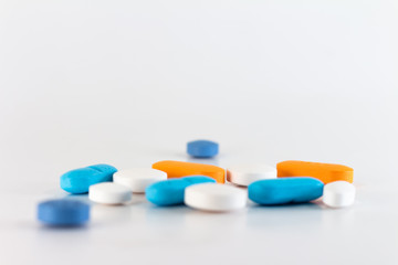 Numerous colored pills on a neutral background.