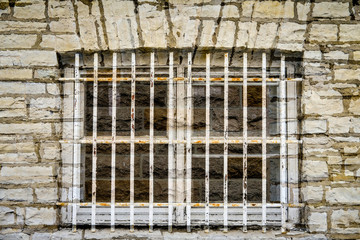 Obraz premium old jail window in limestone wall
