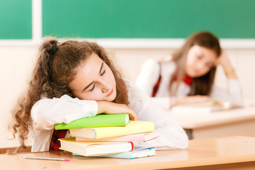 schoolgirls in school uniforms sit for couples in the classroom. Girls go to school.