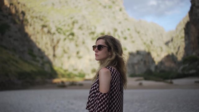 Woman walks by rocks in valley of Torrent de Pareis in Sa Calobra, Mallorca, Spain