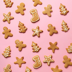Homemade christmas cookies on pink background. Square crop. Pattern of gingerbread men, snowflake, star, fir-tree, boot shapes. New year concept