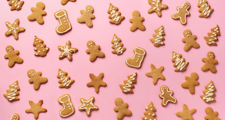 Fototapeta na wymiar Christmas gingerbread cookies on pink background. Banner. Top view, copy space. New year concept