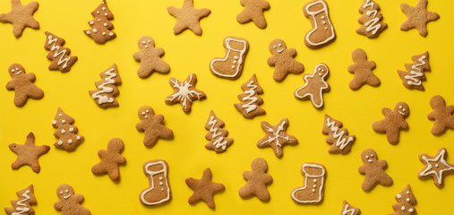 Christmas gingerbread cookies on yellow background. Banner. Top view, copy space. New year concept