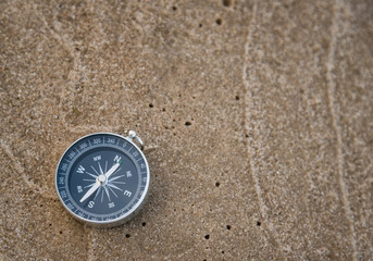 Fototapeta na wymiar Compass on wet sand