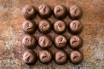pieces of bonbons chocolate on rusty background
