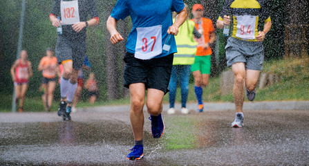 runners running under rain drops city marathon