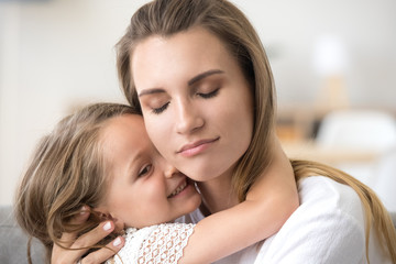 Fototapeta na wymiar Cute little girl hug young mom, touching her face, showing love and care, millennial mother embrace small daughter, feeling sweet tender moment, enjoying time together. Family relationships concept