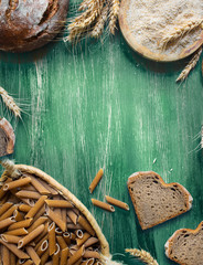Wholemeal pasta and bread on rustic background