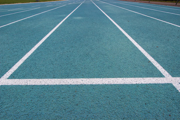 running racetrack with white lines on blue ground