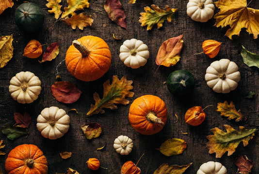 Colourful autumn leaves and pumpkin over old background. Autumn background. Top view.
