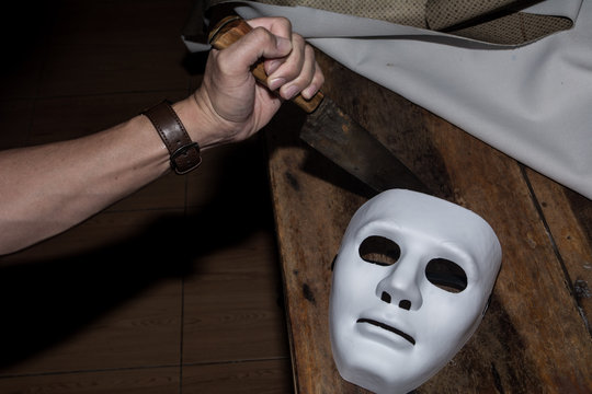 The white mask threatens on the wooden table, killer concept, horror theme , Halloween concepts