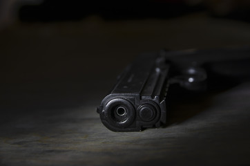 Black Gun on a wooden surface close-up. Studio shot. Top view