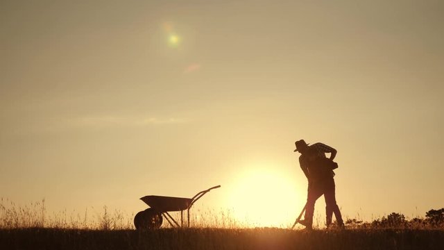 Happy family father and son harvesting in the field at sunset