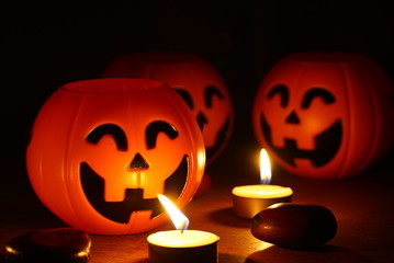 Three pumpkins smile and candle decorate on wood background for halloween night