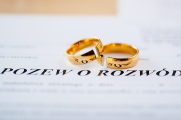 Divorce decree in Polish language and two broken wedding rings