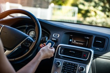 Woman opening automatic property gate with remote control