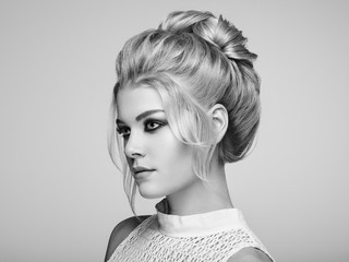 Blonde Girl with Elegant and shiny Hairstyle. Beautiful Model Woman with Curly Hairstyle. Care and Beauty Hair products. Perfect Make-Up