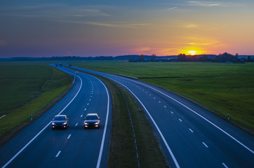 Car driving on the highway at sunset.