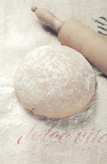 Mound of uncooked dough with rolling pin
