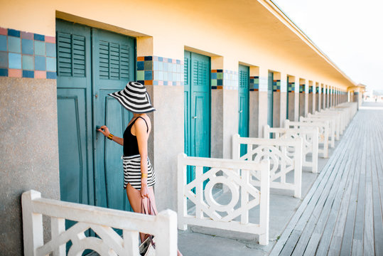 Beautiful woman near the old locker rooms on the beach in Deauville, famous french resort in Normandy