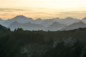 Fototapeta na wymiar Mountain silhouettes with forest and orange sky